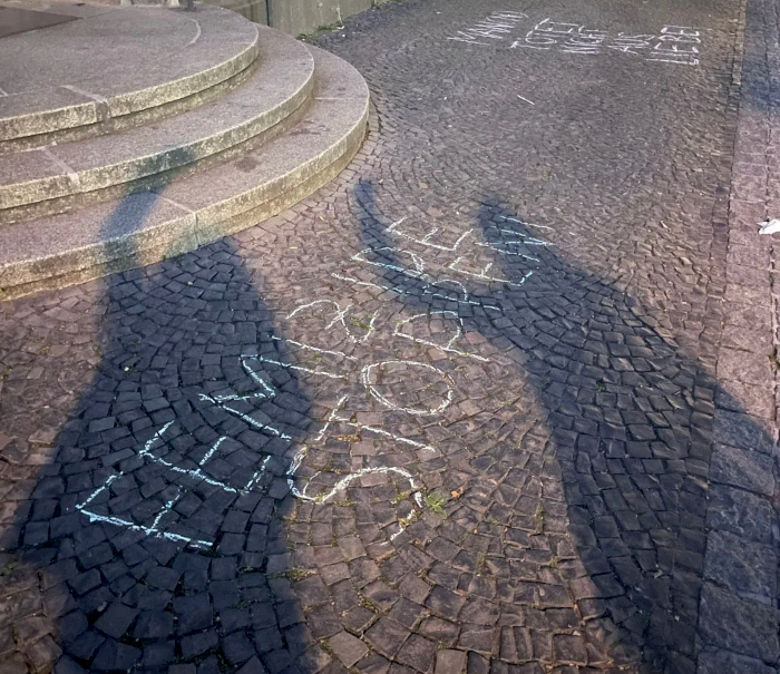 Schrift auf dem Pflaster: FEMIZIDE STOPPEN