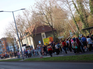 eine langgestreckte Menschenmenge läuft als Demonstration eine Straße entlang