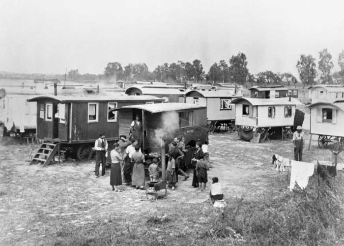 Ansicht des Zwangslagers für Sinti*zze und Rom*nja in Berlin-Marzahn ab 1936 mit mehreren Wohnwagen und einer Personengruppe